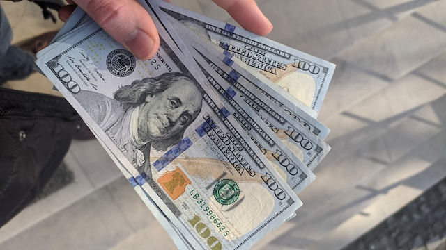 An individual holding dollar bills